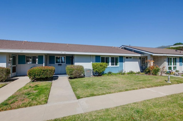 view of front of property featuring a front lawn and central AC unit