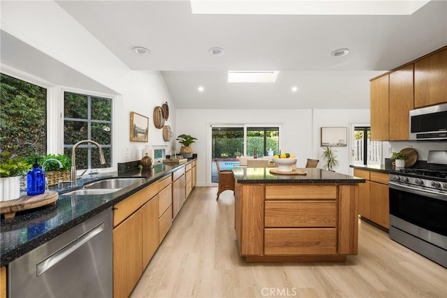 6239 E 6th St, Long Beach, CA 90803 - kitchen with appliances with stainless steel finishes, a sink, a skylight, light wood-type flooring, and dark stone counters