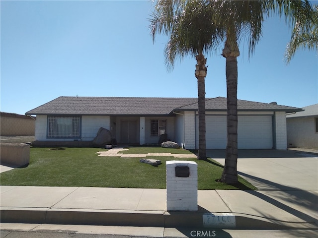 view of front facade with concrete driveway, a front lawn, an attached garage, and brick siding