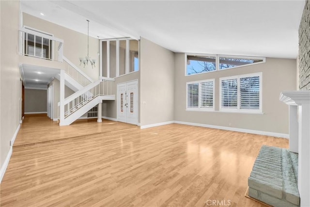 22517 Lazy Meadow Dr, Diamond Bar, CA 91765 - unfurnished living room featuring high vaulted ceiling, stairway, wood finished floors, a chandelier, and baseboards