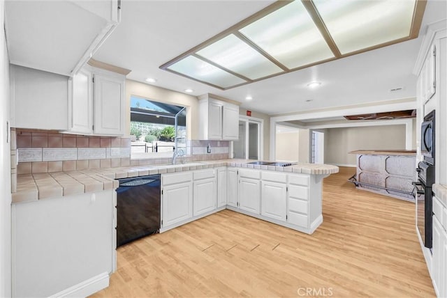 22517 Lazy Meadow Dr, Diamond Bar, CA 91765 - kitchen featuring black appliances, a peninsula, tile countertops, decorative backsplash, and white cabinetry