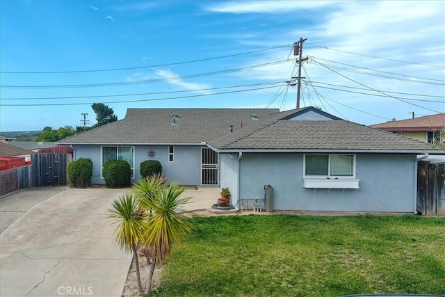 view of front of home with a front yard, fence, and stucco siding