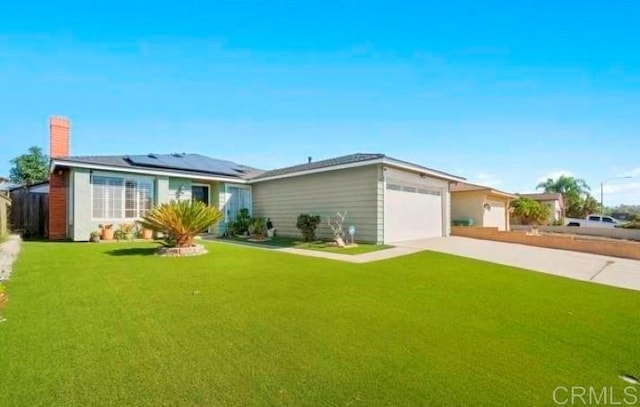 single story home with a garage, solar panels, driveway, a front lawn, and a chimney