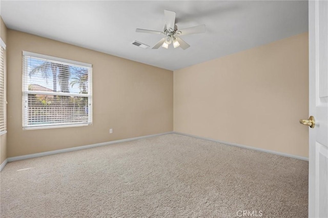 spare room with carpet, visible vents, and baseboards