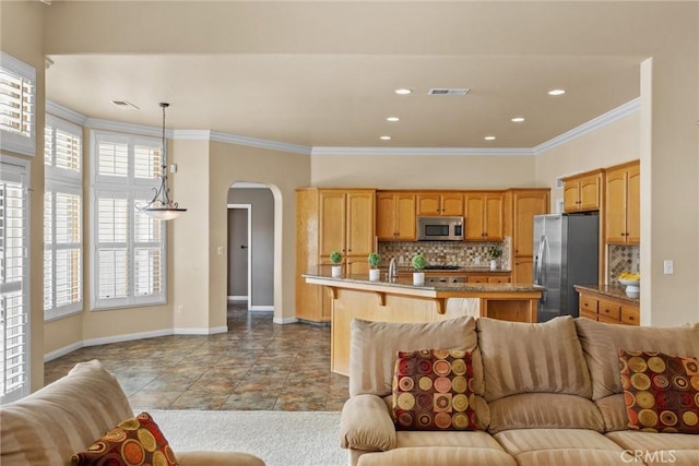 tiled living room with ornamental molding, arched walkways, visible vents, and baseboards