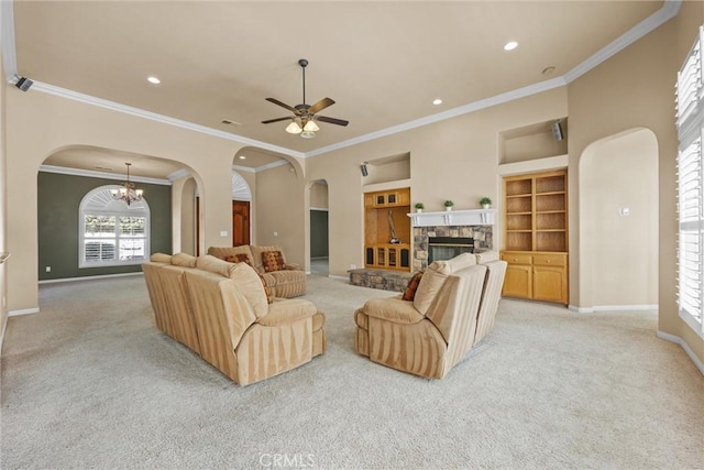 living area with arched walkways, light colored carpet, a fireplace, and baseboards