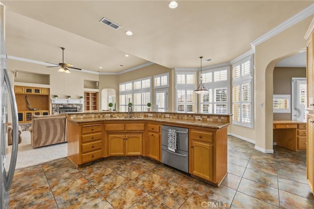 kitchen featuring stainless steel appliances, a fireplace, a sink, visible vents, and ornamental molding