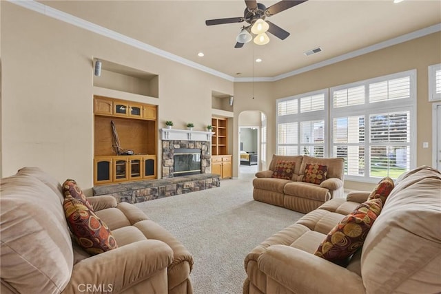 living room with crown molding, a fireplace, built in features, and carpet flooring