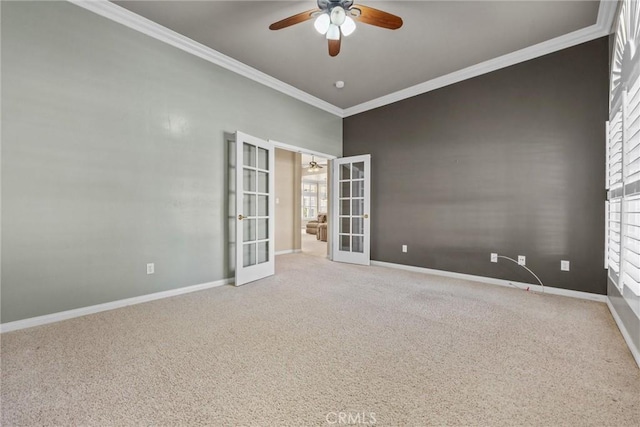 carpeted spare room featuring ornamental molding, ceiling fan, french doors, and baseboards