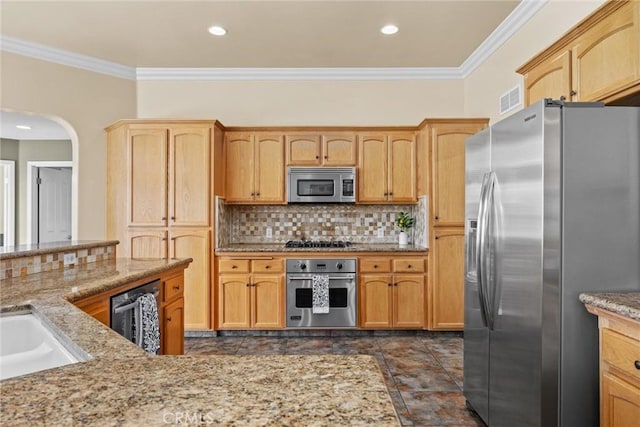 kitchen with appliances with stainless steel finishes, backsplash, visible vents, and crown molding