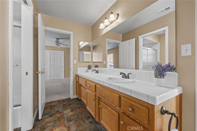 bathroom with an enclosed shower, visible vents, a sink, and double vanity