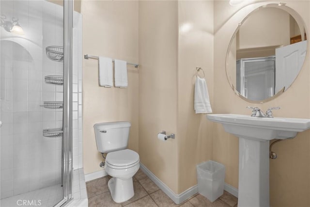 full bathroom featuring toilet, a shower stall, baseboards, and tile patterned flooring