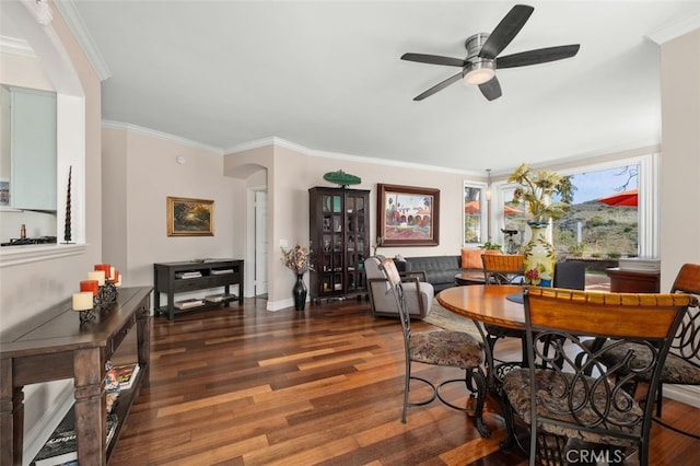 dining space featuring ornamental molding, wood finished floors, a ceiling fan, and baseboards