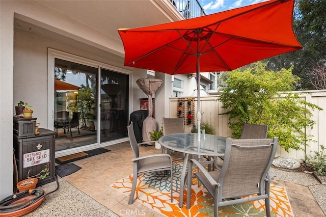 view of patio featuring outdoor dining space and fence