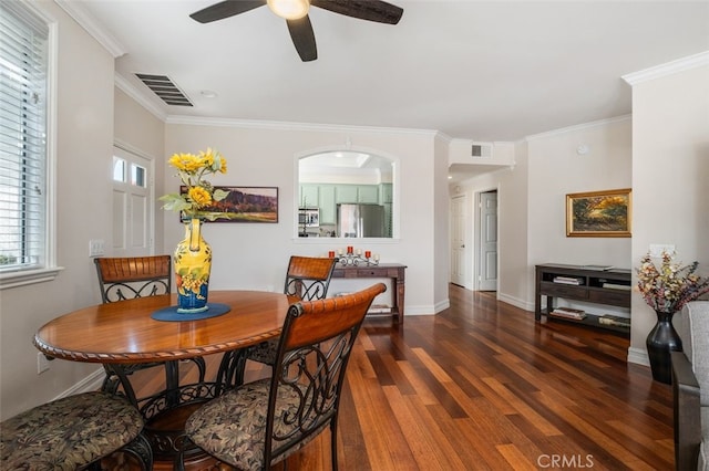 dining area featuring ornamental molding, visible vents, baseboards, and wood finished floors