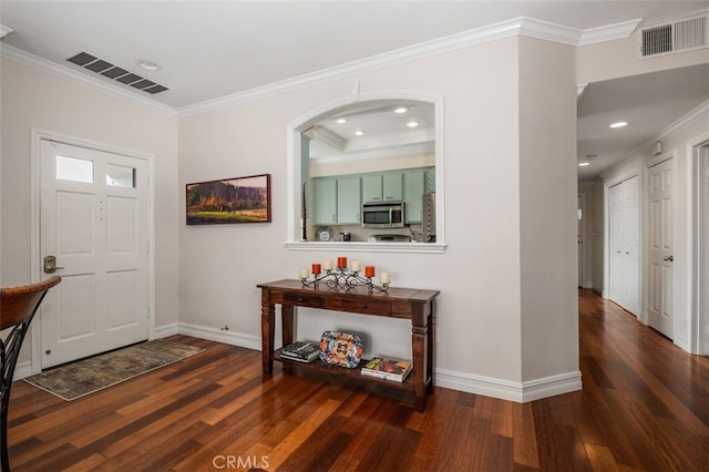 foyer featuring ornamental molding, visible vents, and wood finished floors