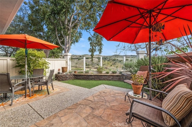 view of patio with outdoor dining area and fence