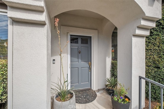 doorway to property featuring stucco siding