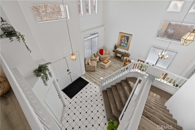 foyer featuring a chandelier, a high ceiling, stairway, and wood finished floors