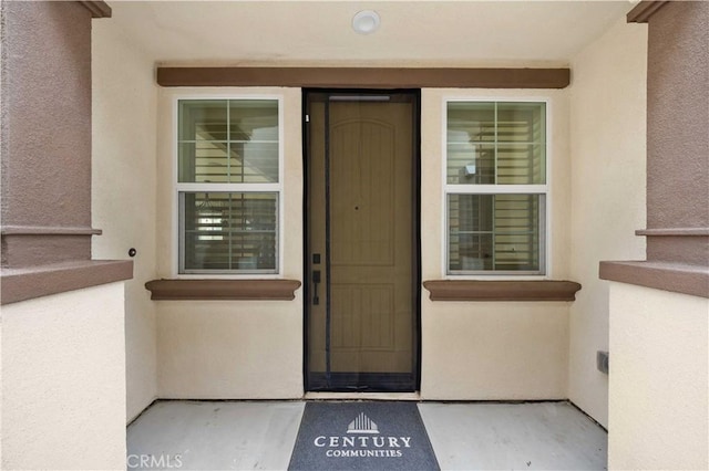 view of exterior entry featuring stucco siding