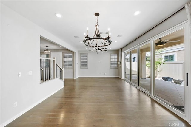 interior space with stairs, recessed lighting, wood finished floors, baseboards, and ceiling fan with notable chandelier