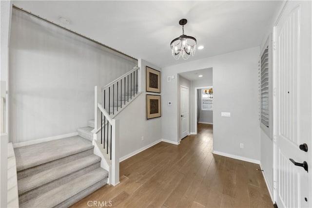 staircase featuring a chandelier, recessed lighting, wood-type flooring, and baseboards