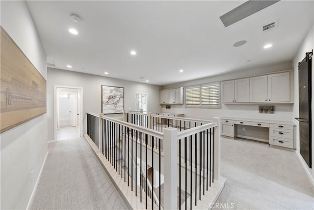 hall with recessed lighting, light colored carpet, an upstairs landing, baseboards, and visible vents