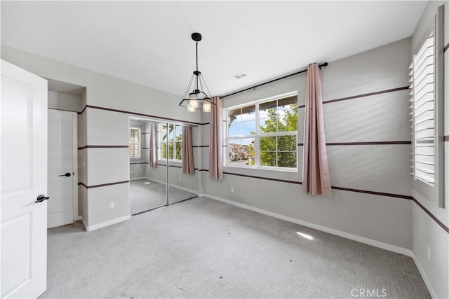 interior space with a notable chandelier, baseboards, visible vents, and carpet flooring