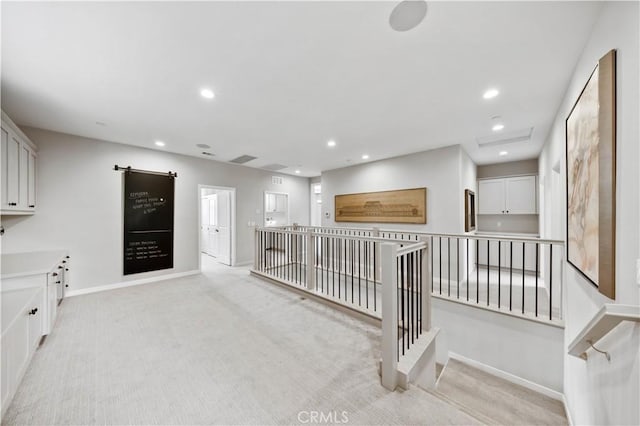 hall with baseboards, light carpet, and recessed lighting