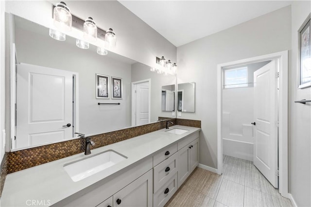 bathroom with double vanity, tile patterned flooring, baseboards, and a sink