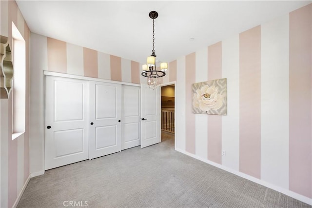 interior space featuring light carpet, wallpapered walls, and baseboards