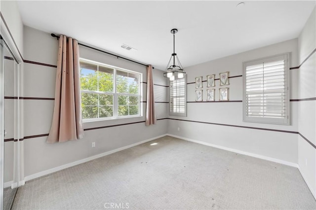 unfurnished room with carpet, visible vents, and baseboards