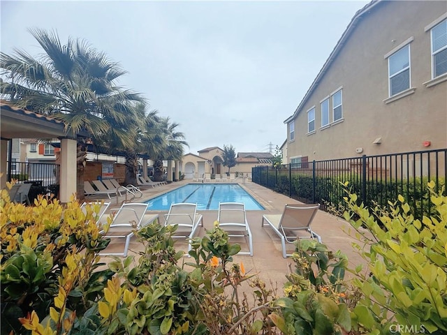 pool with fence and a patio