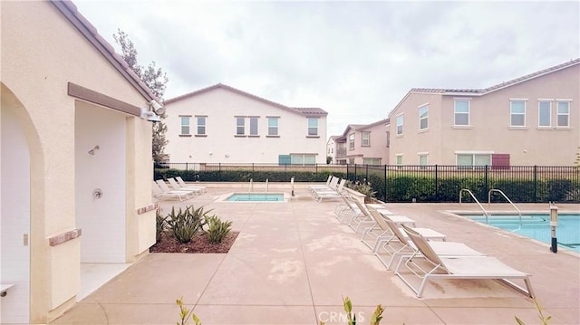 community pool featuring a patio area and fence