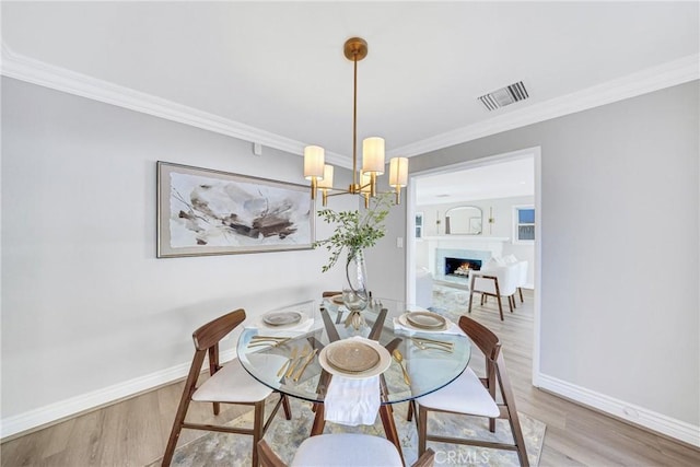3024 Via Rivera, Palos Verdes Estates, CA 90274 - dining space with wood finished floors, a chandelier, crown molding, and a lit fireplace