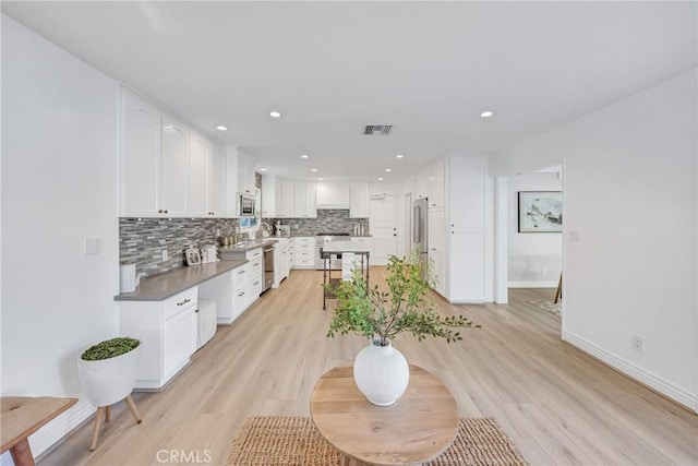 3024 Via Rivera, Palos Verdes Estates, CA 90274 - kitchen featuring stainless steel appliances, decorative backsplash, white cabinetry, light wood finished floors, and recessed lighting