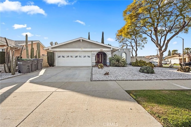 single story home with concrete driveway, an attached garage, and stucco siding