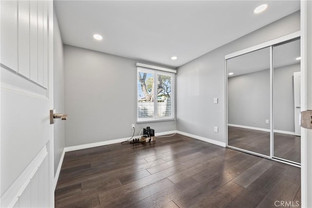 unfurnished bedroom featuring baseboards, wood finished floors, and recessed lighting