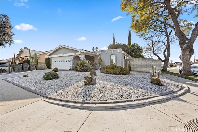 view of front of property featuring a garage, fence, and driveway