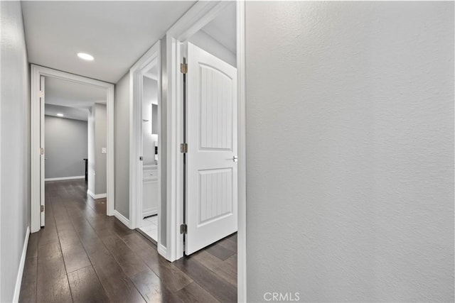 hall featuring dark wood-style floors and baseboards