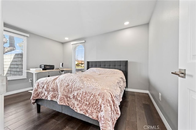 bedroom featuring multiple windows, baseboards, and dark wood finished floors