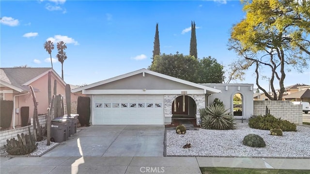 view of front of property with a garage, concrete driveway, fence, and stucco siding