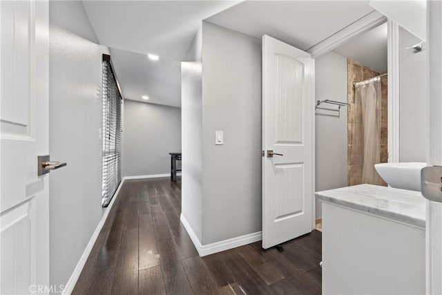 corridor featuring dark wood-style floors and baseboards