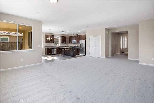 4907 Durant Way, Merced, CA 95348 - unfurnished living room featuring baseboards, recessed lighting, and light carpet