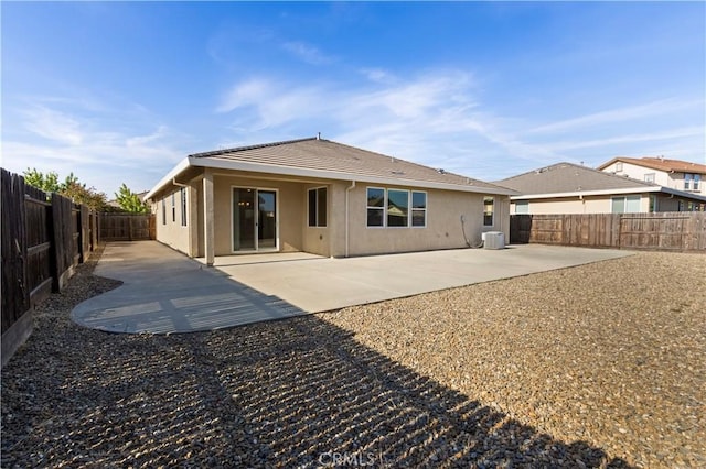 4907 Durant Way, Merced, CA 95348 - rear view of house featuring a tile roof, a patio area, central AC, a fenced backyard, and stucco siding