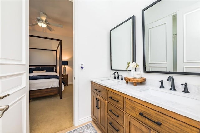 bathroom featuring ensuite bathroom, double vanity, a sink, and a ceiling fan