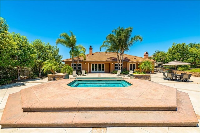 view of pool featuring french doors, a patio area, and a pool