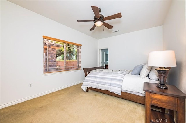 carpeted bedroom featuring a ceiling fan, visible vents, and baseboards