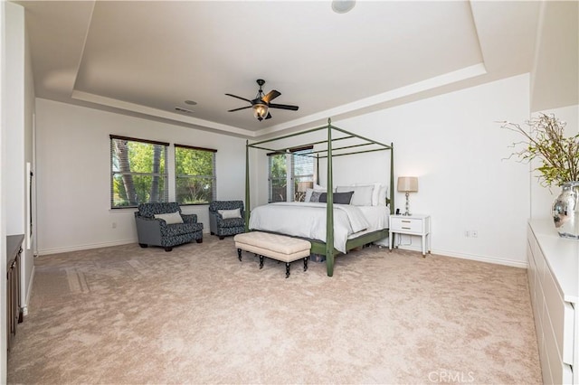 bedroom with baseboards, a tray ceiling, ceiling fan, and light colored carpet