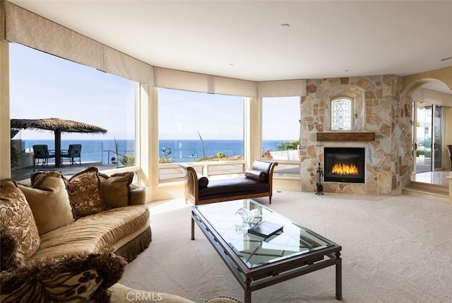 3824 Vista Blanca, San Clemente, CA 92672 - living room featuring carpet floors, a stone fireplace, arched walkways, and a water view